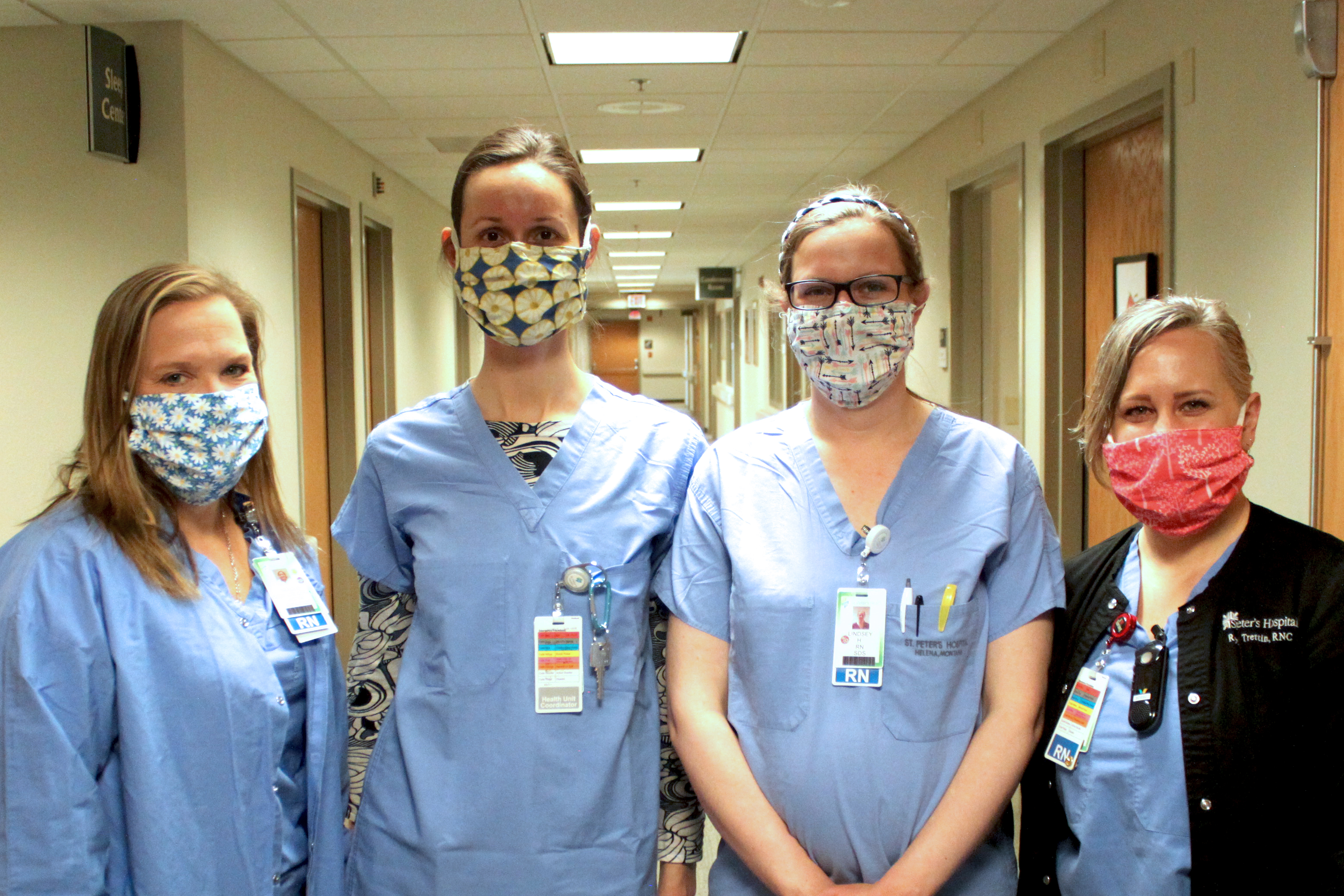 Caregivers pose wearing cloth masks donated by community members