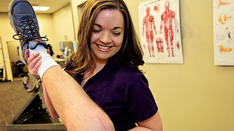 physical therapist with patient's leg