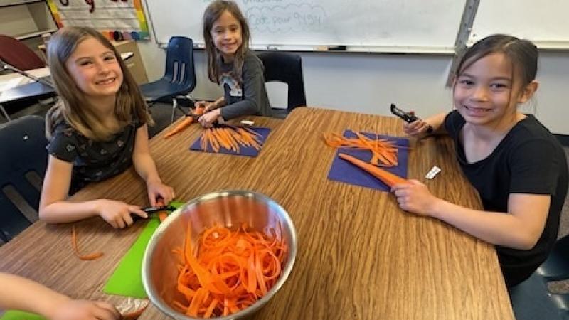 students peeling carrots